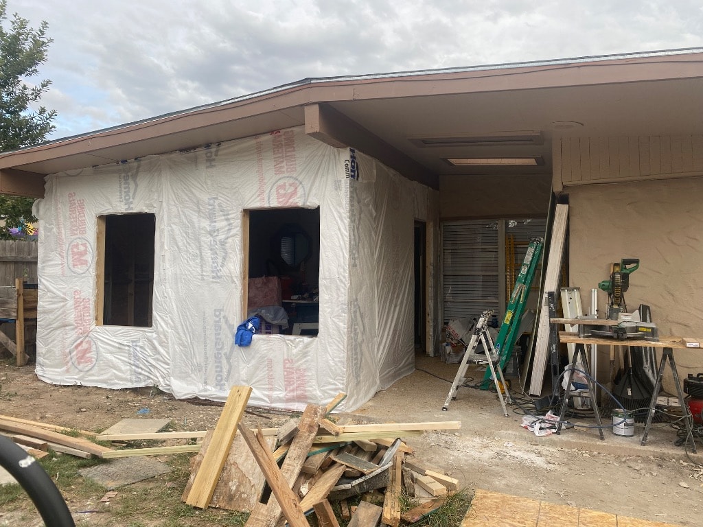 Finished interior of kitchen addition with smooth painted drywall, recessed lighting installed, new windows set, and skylight — ready for flooring and cabinets