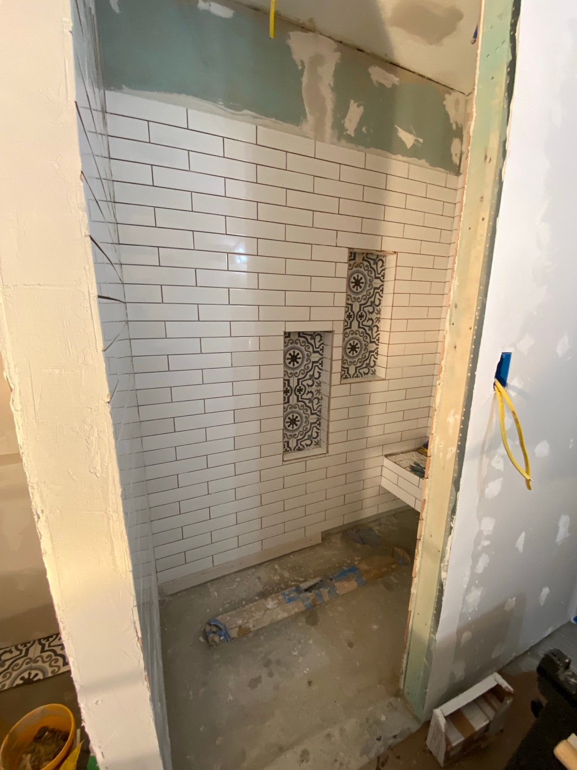 Bathroom renovation showing new stud framing, cement board, and rough construction phase before tile
