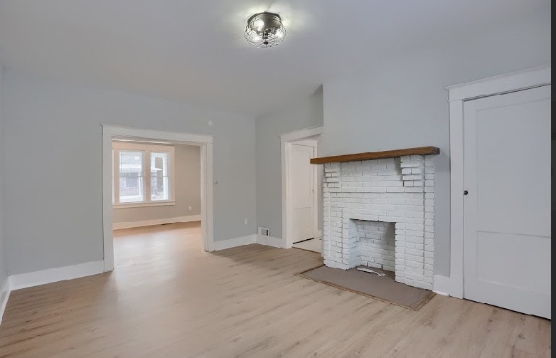 Completed bedroom with sage green accent paint, crisp white trim, light hardwood flooring, and craftsman-style door