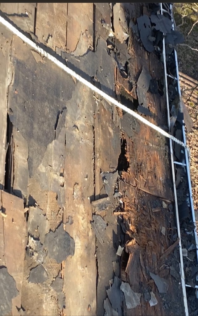 Roof demo phase showing deteriorated old decking and shingles stripped before new installation